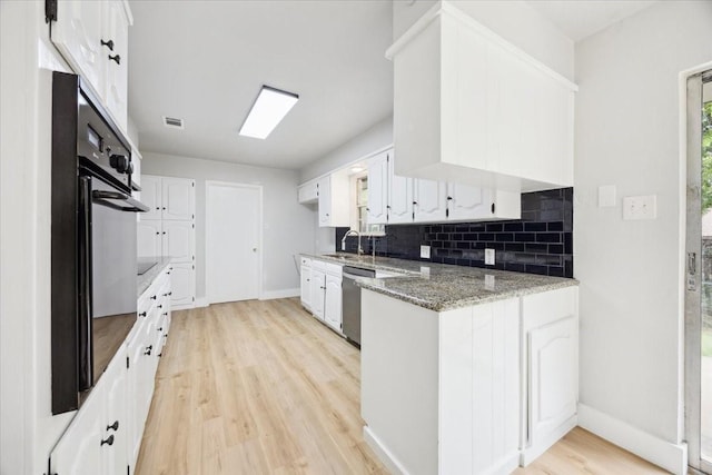 4132 Alava Dr, Fort Worth, TX 76133 - kitchen with backsplash, white cabinetry, light wood-type flooring, black oven, and light stone counters