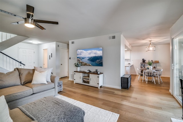 9707 Highland View Dr, Dallas, TX 75238 - living area with light wood-type flooring, ceiling fan, and stairway