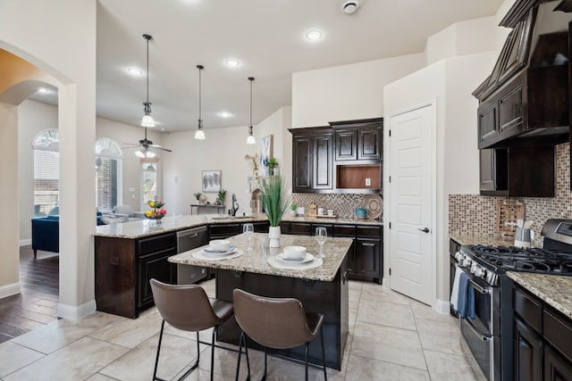 1256 Teton Dr, Burleson, TX 76028 - kitchen featuring stainless steel appliances, arched walkways, decorative backsplash, dark brown cabinetry, and recessed lighting