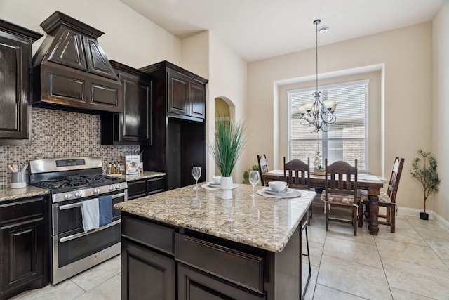 1256 Teton Dr, Burleson, TX 76028 - kitchen featuring range with two ovens, light tile patterned floors, arched walkways, decorative backsplash, and light stone counters