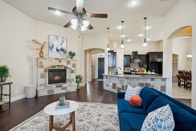 1256 Teton Dr, Burleson, TX 76028 - living room with arched walkways, ceiling fan, a fireplace, dark wood-style flooring, and recessed lighting