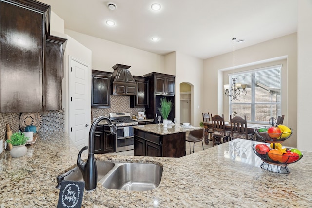 1256 Teton Dr, Burleson, TX 76028 - kitchen featuring stainless steel range with gas stovetop, a chandelier, decorative backsplash, dark brown cabinets, and light stone countertops