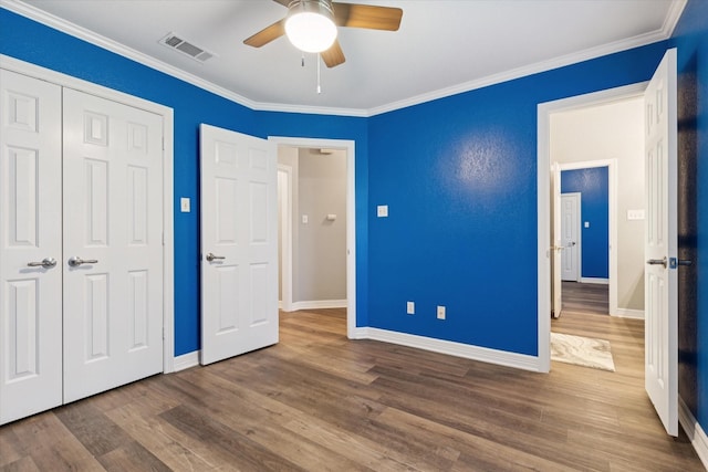 1005 Prairie Ln, Mcgregor, TX 76657 - unfurnished bedroom with wood finished floors, a closet, ornamental molding, and ceiling fan