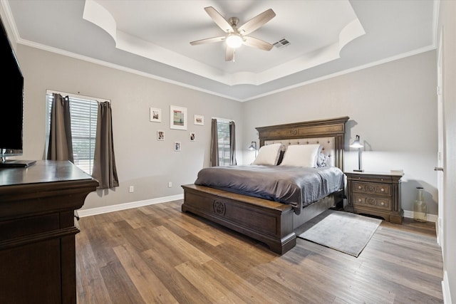 1005 Prairie Ln, Mcgregor, TX 76657 - bedroom featuring a tray ceiling, wood finished floors, a ceiling fan, and ornamental molding