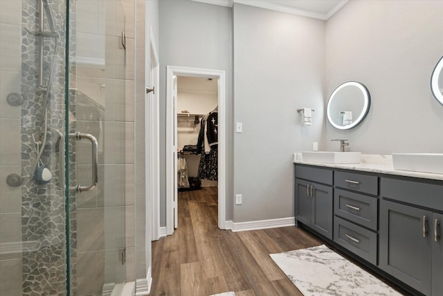 1005 Prairie Ln, Mcgregor, TX 76657 - bathroom with ornamental molding, vanity, a shower stall, a spacious closet, and wood finished floors