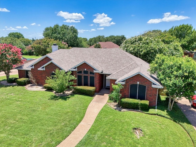 1005 Prairie Ln, Mcgregor, TX 76657 - view of front of property featuring a front lawn, brick siding, and a shingled roof