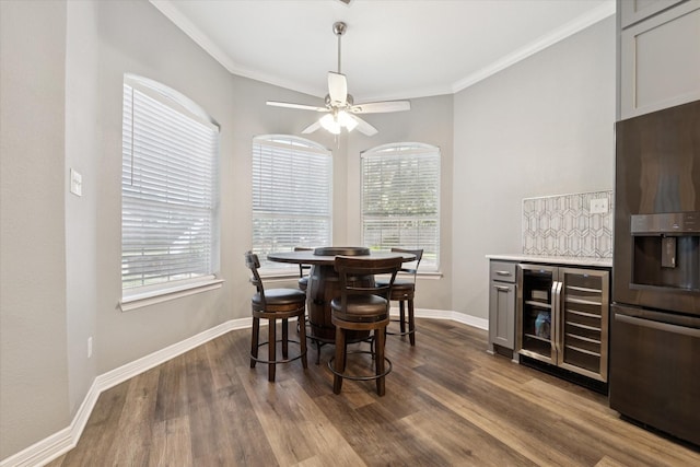 1005 Prairie Ln, Mcgregor, TX 76657 - dining area featuring wine cooler, healthy amount of natural light, dark wood-type flooring, ornamental molding, and ceiling fan