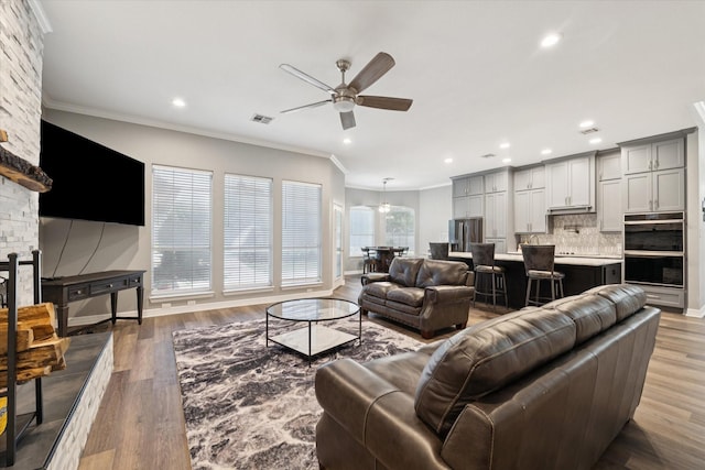 1005 Prairie Ln, Mcgregor, TX 76657 - living area with ceiling fan, wood finished floors, crown molding, and recessed lighting