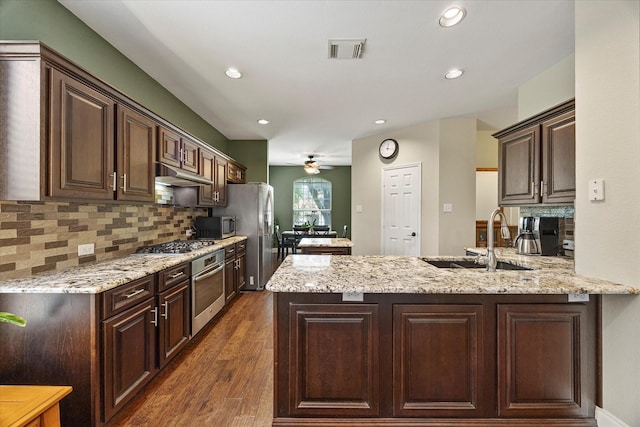 1045 Hillcrest Cir, Rockwall, TX 75087 - kitchen featuring stainless steel appliances, ceiling fan, a peninsula, dark brown cabinetry, and recessed lighting