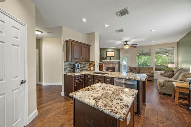 1045 Hillcrest Cir, Rockwall, TX 75087 - kitchen featuring a peninsula, open floor plan, ceiling fan, a brick fireplace, and recessed lighting