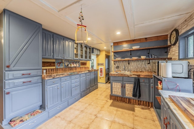 2057 Breezywood Dr, Flower Mound, TX 75022 - kitchen featuring open shelves, recessed lighting, gray cabinetry, tasteful backsplash, and glass insert cabinets