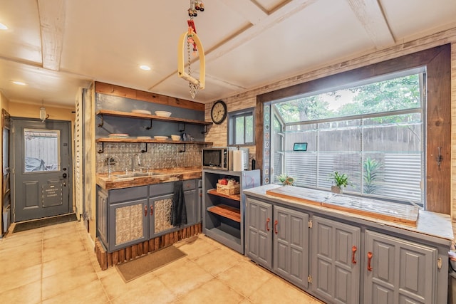 2057 Breezywood Dr, Flower Mound, TX 75022 - kitchen with open shelves, gray cabinets, stainless steel microwave, backsplash, and light countertops