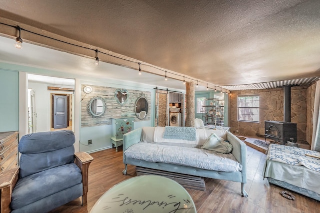 2057 Breezywood Dr, Flower Mound, TX 75022 - living room with track lighting, hardwood / wood-style flooring, a wood stove, a textured ceiling, and a barn door