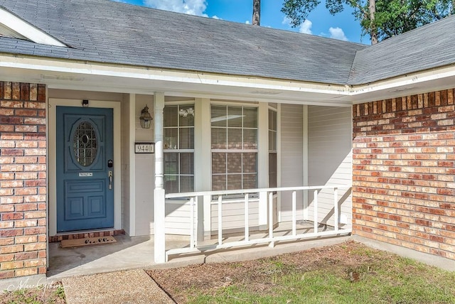 9440 Castlebrook Dr, Shreveport, LA 71129 - property entrance with brick siding, a shingled roof, and a porch