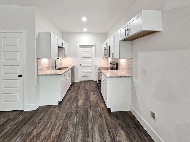 140 Mohican Trl, Mabank, TX 75156 - kitchen with appliances with stainless steel finishes, tasteful backsplash, light stone counters, dark wood-style floors, and recessed lighting