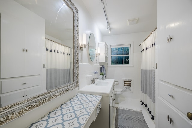 6420 Waverly Way, Fort Worth, TX 76116 - bathroom featuring heating unit, vanity, a shower with curtain, tile walls, and track lighting
