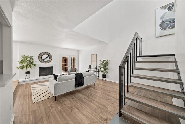 9206 Flickering Shadow Dr, Dallas, TX 75243 - living area featuring stairway, wood finished floors, and a fireplace