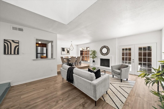 9206 Flickering Shadow Dr, Dallas, TX 75243 - living area with wood finished floors, french doors, and a textured ceiling