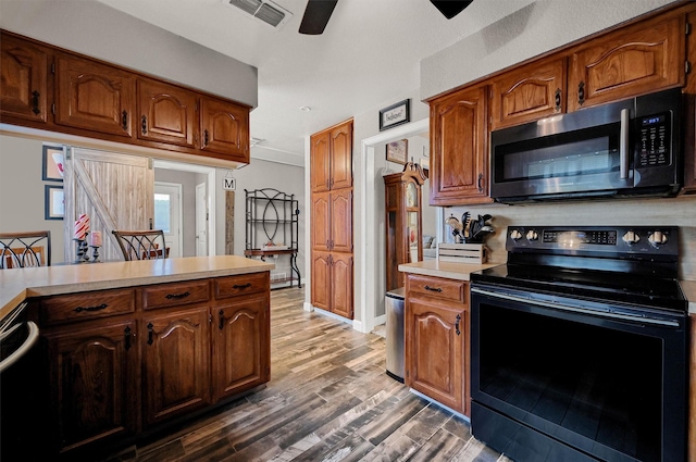 2212 Fred Smith Pkwy, Celina, TX 75009 - kitchen featuring black range with electric stovetop, stainless steel microwave, light countertops, ceiling fan, and wood finished floors