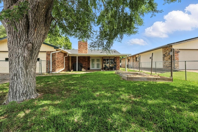 4201 Blackwillow Dr, Mesquite, TX 75150 - back of property featuring french doors, a chimney, brick siding, and a vegetable garden