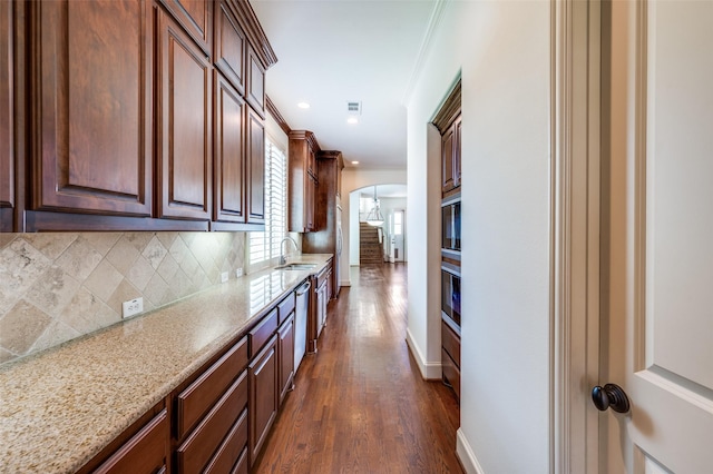 8540 Canyon Xing, Lantana, TX 76226 - kitchen featuring arched walkways, backsplash, light stone countertops, dark wood-style floors, and ornamental molding