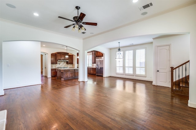 8540 Canyon Xing, Lantana, TX 76226 - unfurnished living room featuring arched walkways, ceiling fan, dark wood-style flooring, stairs, and crown molding