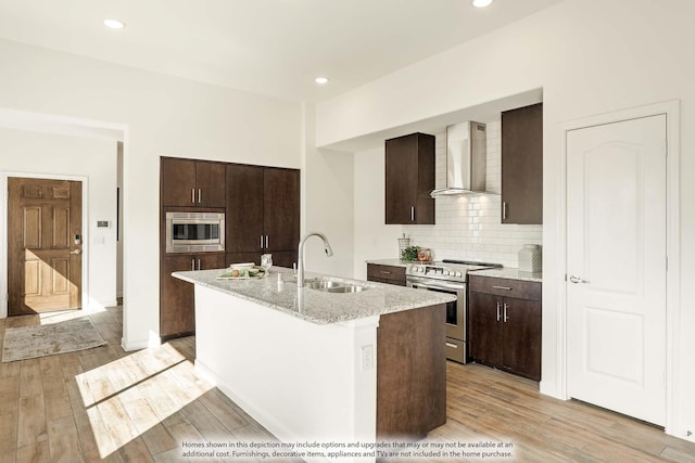 155 Wild Oak Gln, Lavon, TX 75166 - kitchen featuring wall chimney exhaust hood, appliances with stainless steel finishes, dark brown cabinets, a kitchen island with sink, and recessed lighting