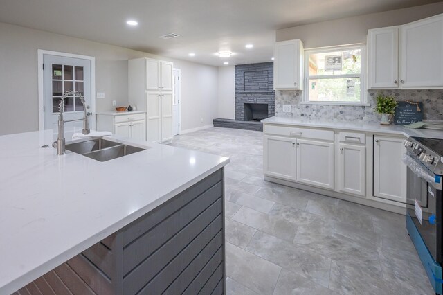 820 Vickie Dr, Azle, TX 76020 - kitchen featuring stainless steel range with electric cooktop, a fireplace, backsplash, white cabinetry, and recessed lighting