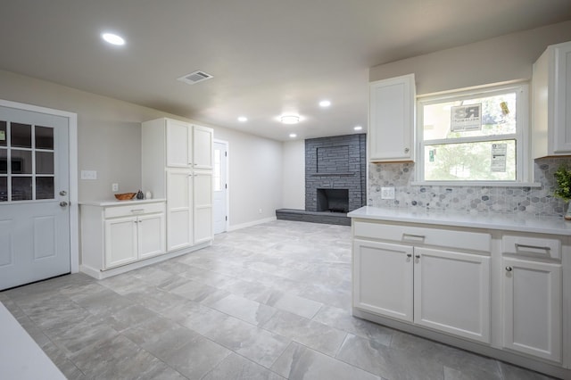 820 Vickie Dr, Azle, TX 76020 - kitchen featuring backsplash, a stone fireplace, white cabinets, light countertops, and recessed lighting