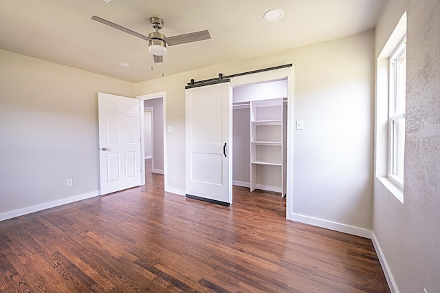 820 Vickie Dr, Azle, TX 76020 - unfurnished bedroom featuring multiple windows, a barn door, wood finished floors, and a ceiling fan