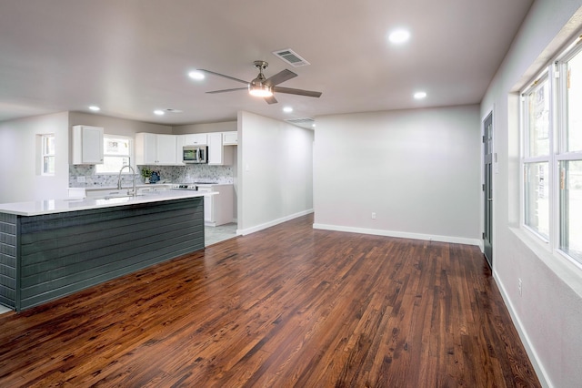 820 Vickie Dr, Azle, TX 76020 - kitchen with stainless steel microwave, dark wood-style flooring, light countertops, white cabinets, and recessed lighting