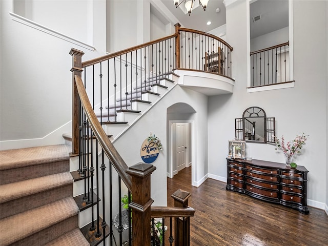 604 Rough Creek Dr, Mckinney, TX 75071 - stairway with arched walkways, wood finished floors, a high ceiling, a chandelier, and recessed lighting