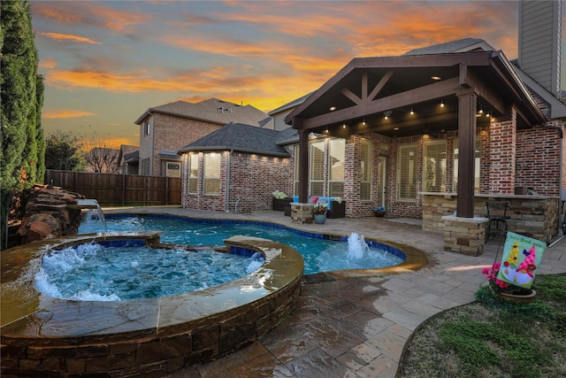 604 Rough Creek Dr, Mckinney, TX 75071 - pool at dusk featuring a fenced backyard, a patio area, and a pool with connected hot tub
