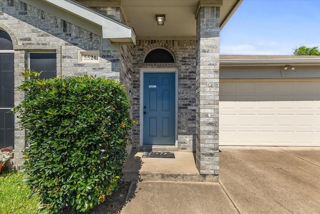 5521 Alta Verde Cir, Arlington, TX 76017 - property entrance with driveway, an attached garage, and stone siding