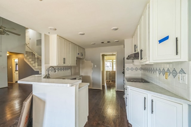 17 Zachary Ct, Mansfield, TX 76063 - kitchen with under cabinet range hood, black electric stovetop, a peninsula, dark wood finished floors, and decorative backsplash