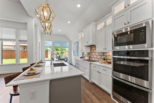 8133 Blumelia Dr, Dallas, TX 75252 - kitchen with vaulted ceiling, stainless steel appliances, a chandelier, dark wood-style floors, and light countertops