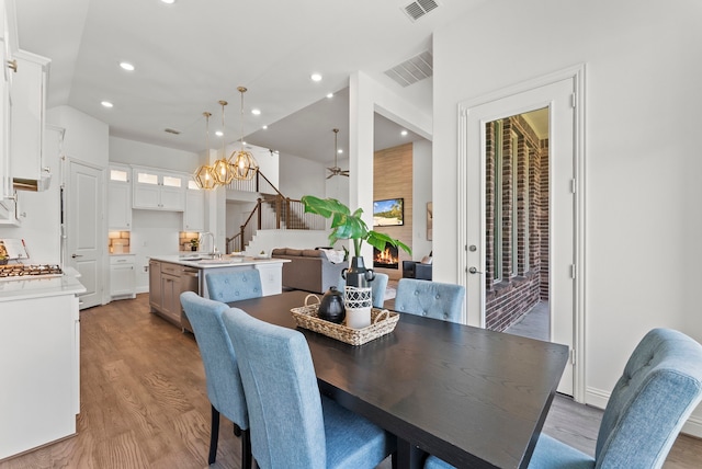 8133 Blumelia Dr, Dallas, TX 75252 - dining area featuring stairway, light wood-style flooring, a chandelier, and recessed lighting
