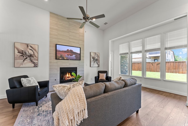 8133 Blumelia Dr, Dallas, TX 75252 - living area featuring a fireplace, wood finished floors, a high ceiling, and ceiling fan