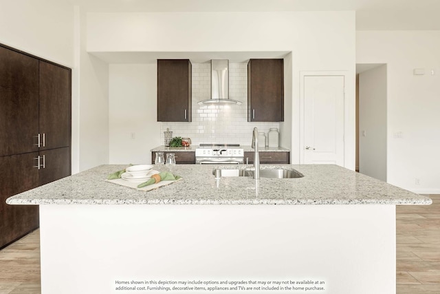 111 Cedar Grove Ct, Lavon, TX 75166 - kitchen featuring wall chimney exhaust hood, light wood-style flooring, dark brown cabinets, and a kitchen island with sink