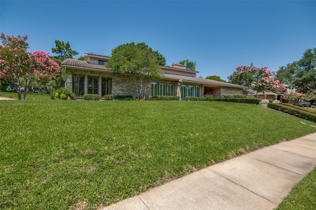 100 La Paz Ct, Irving, TX 75062 - view of front of house with a front lawn, stone siding, and a chimney