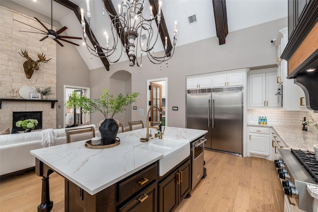 3208 Twin Eagles Dr, Celina, TX 75009 - kitchen featuring stainless steel appliances, high vaulted ceiling, beamed ceiling, a ceiling fan, and white cabinets
