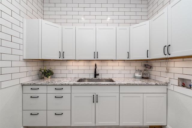 3208 Twin Eagles Dr, Celina, TX 75009 - kitchen featuring light stone countertops, white cabinetry, and backsplash