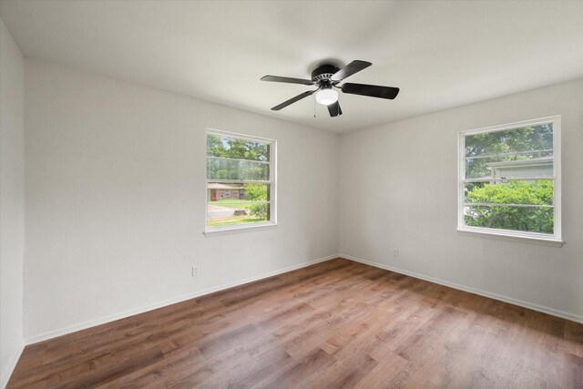 2040 Bowie Dr, Corsicana, TX 75110 - empty room featuring healthy amount of natural light, wood finished floors, and a ceiling fan