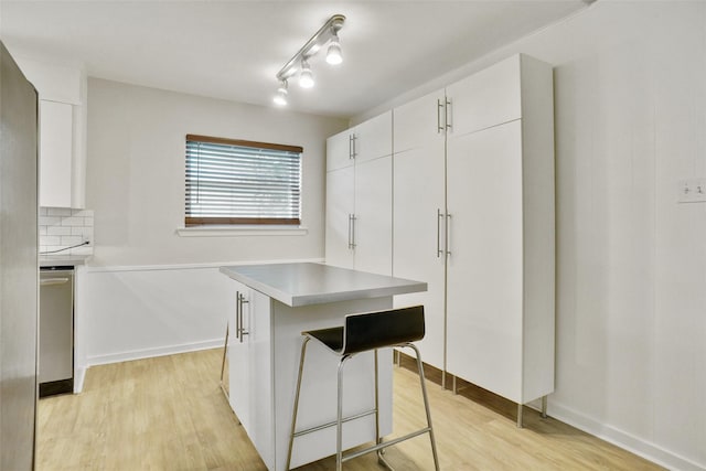 108 Sunnyvale Ter, Hurst, TX 76053 - kitchen featuring white cabinets, light wood-style flooring, and a kitchen island