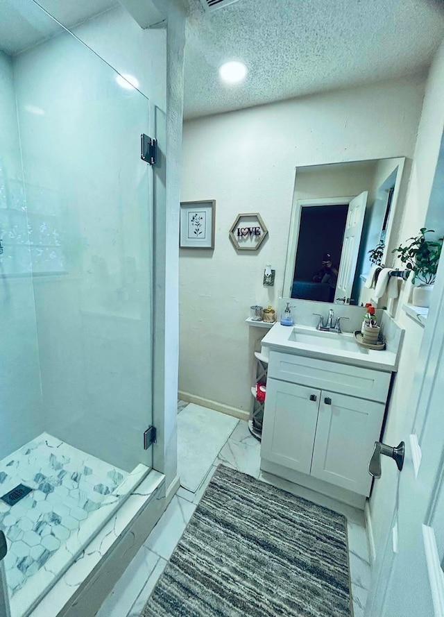 307 E 5th St, Kaufman, TX 75142 - full bathroom with a stall shower, vanity, marble look tile flooring, and a textured ceiling
