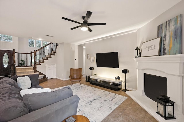 13242 Grayhawk Blvd, Frisco, TX 75033 - tiled living room with stairs, a ceiling fan, and a fireplace with raised hearth