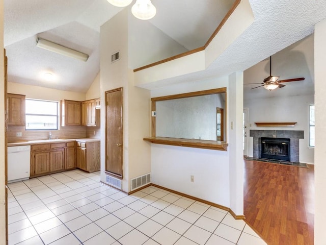 10200 Pack Saddle Ct, Fort Worth, TX 76108 - kitchen with dishwasher, vaulted ceiling, ceiling fan, light countertops, and a fireplace