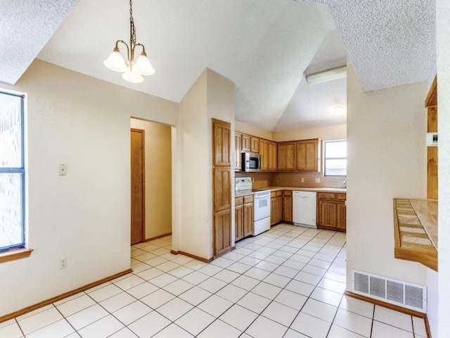 10200 Pack Saddle Ct, Fort Worth, TX 76108 - kitchen with white appliances, light countertops, lofted ceiling, hanging light fixtures, and light tile patterned floors