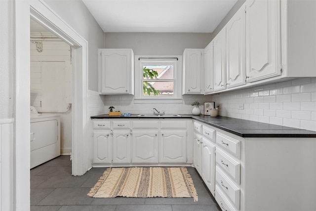 2700 Ethel Ave, Waco, TX 76707 - kitchen with washer / clothes dryer, dark countertops, white cabinetry, and tile patterned floors