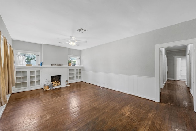 2700 Ethel Ave, Waco, TX 76707 - unfurnished living room with wood finished floors, a fireplace, ceiling fan, and wainscoting